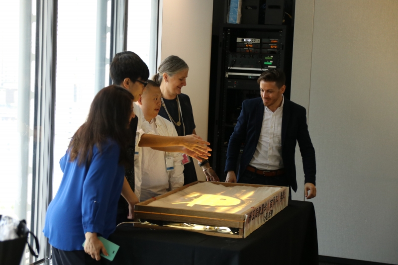 4 people gather around a light box display