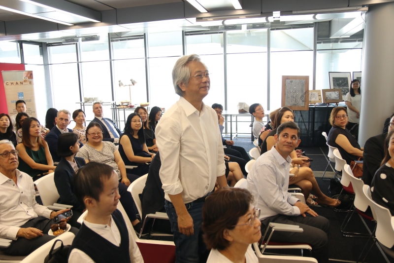 man stands amongst seated event participants