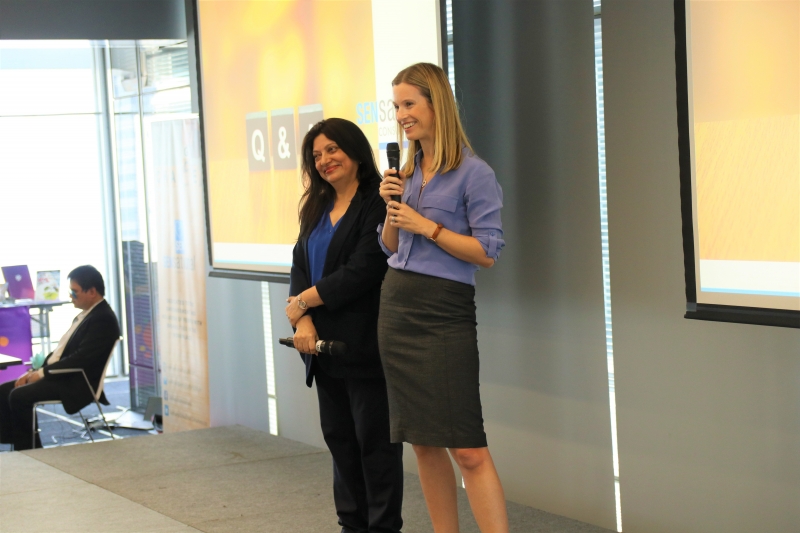 two women stand on stage presenting