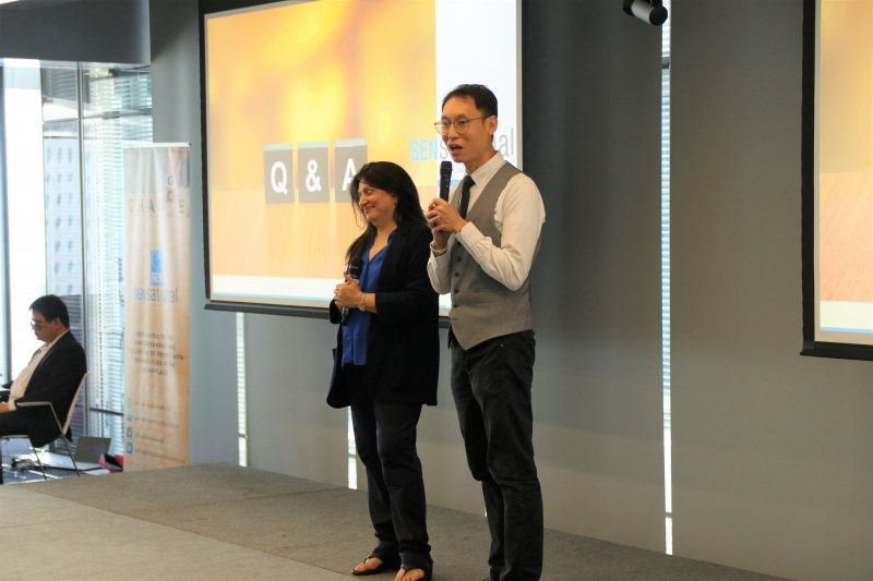 man and woman stand presenting on stage