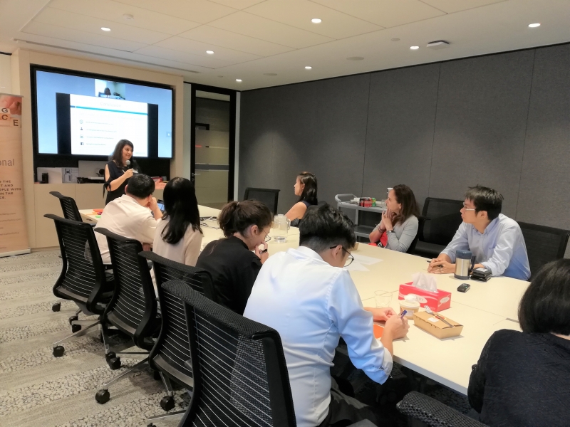 group of corporate employees sitting in a conference room and listening to a presentation