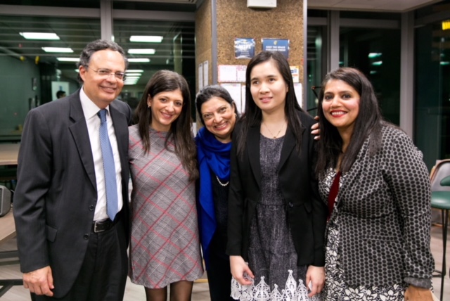 4 women and a man in business attire are grouped together for a group photo