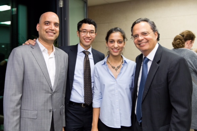 3 men and a woman in business attire are grouped together for a photo