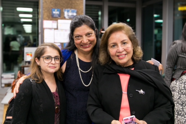 3 women in business attire are grouped together for a photo