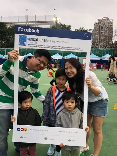 A family of 5 (2 parents and 3 sons) can be seen posing behind the SENsational Facebook post photo frame