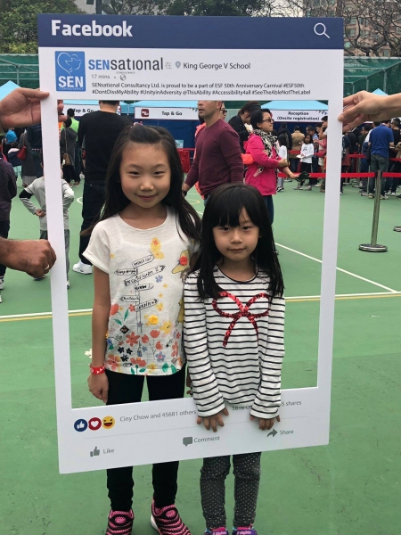2 girls can be seen posing behind the SENsational Facebook post photo frame