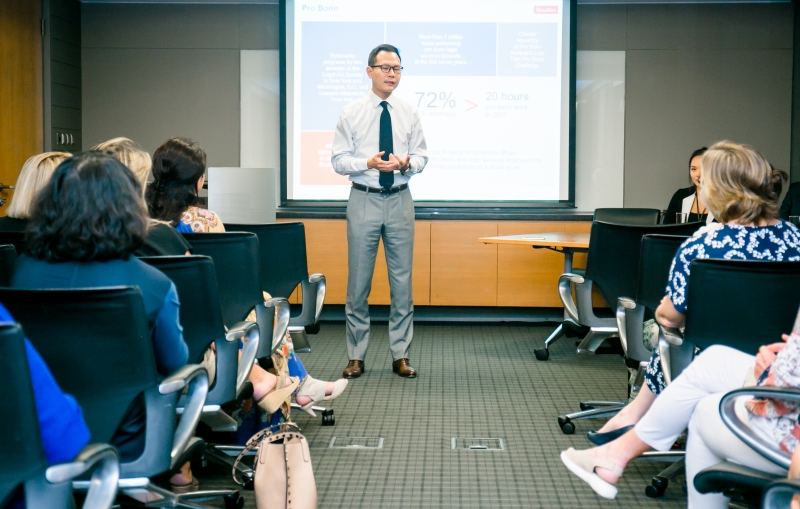 A male Skadden staff giving a presentation, on either side of the picture audience members can be seen seated in rows listening to the presentation.