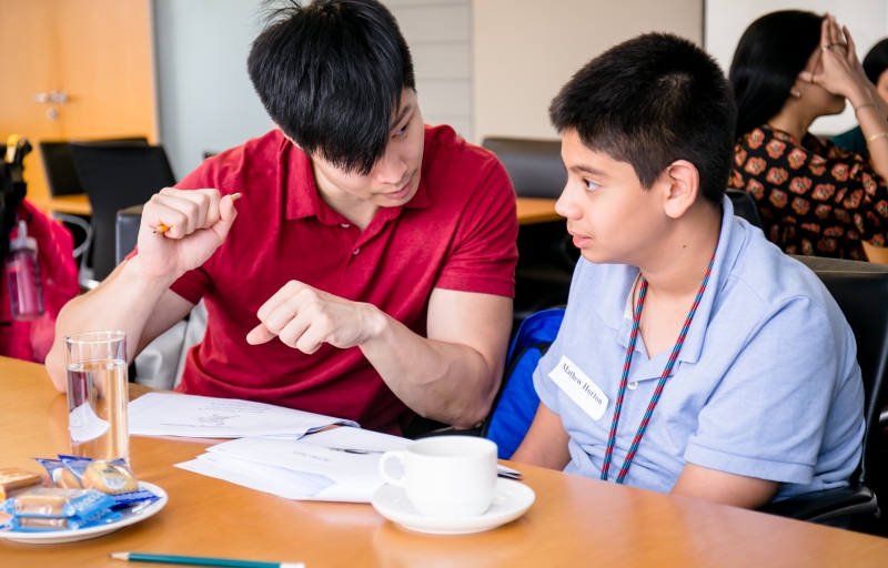 A Skadden staff member is working together with a training seminar student to help complete an activity