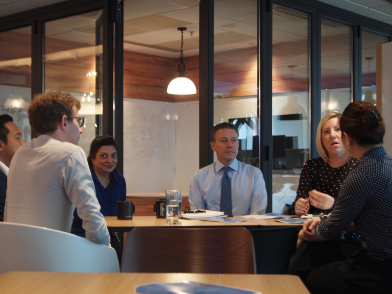 SENsational and Colliers staff in business attire are seated at a table having a group discussion