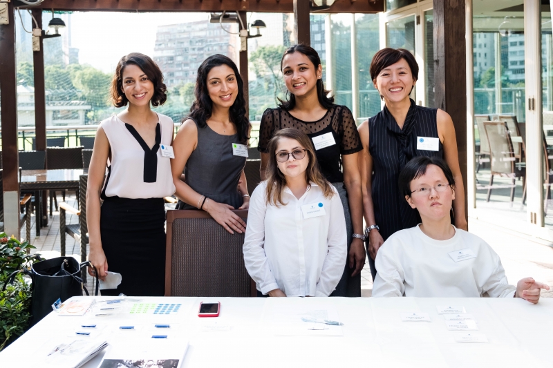 A photo of 6 women in business attire who are SENsational staff members, 2 are seated by a table with 4 standing behind them.