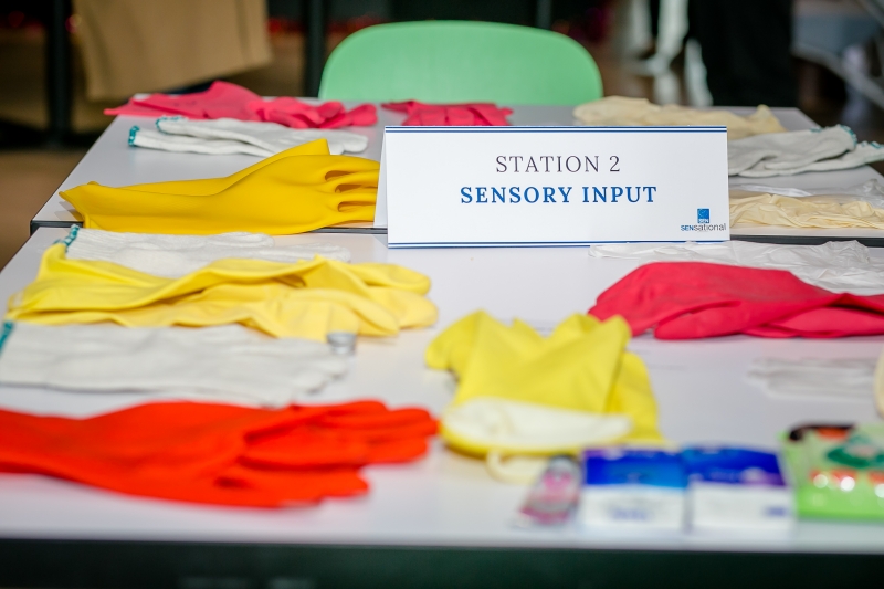 Gloves on a table with a sign saying "Sensory Input"