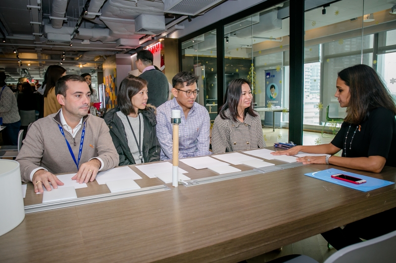 3 women and 2 men around a table having a group discussion