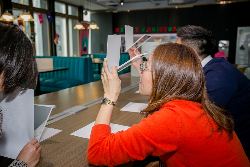 AXA staff sitting at a table undergoing dyslexia reading simulation