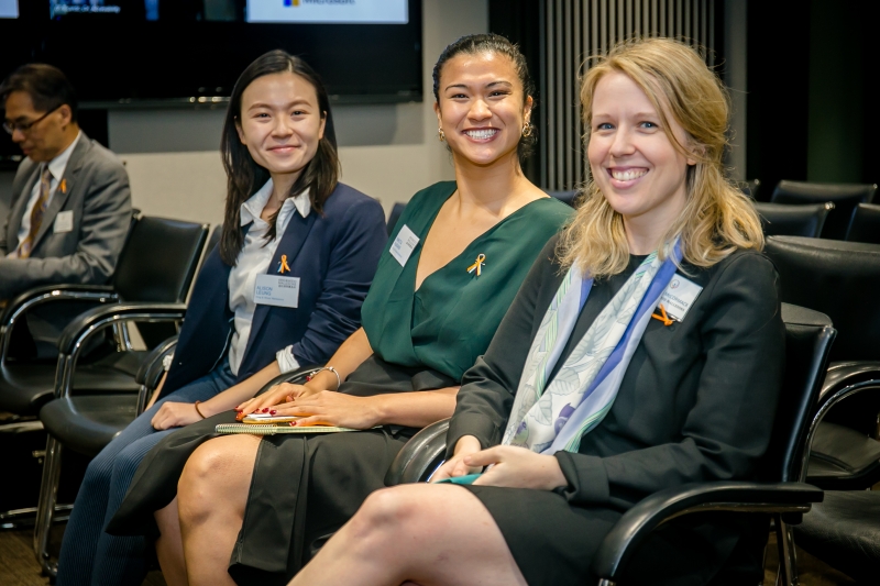 3 women in business attire sitting on chairs