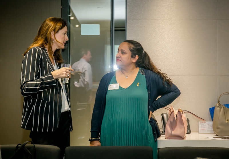 2 women in business attire having a conversation