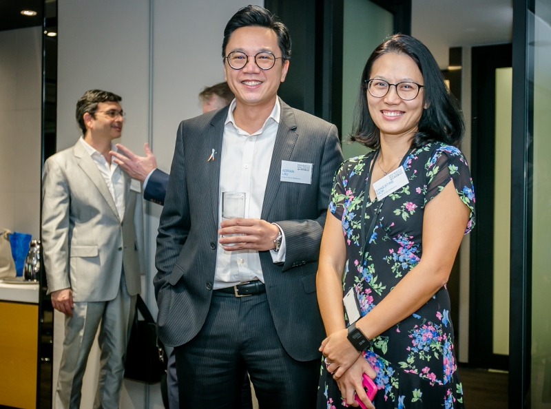A man and a woman in business attire smiling at the camera
