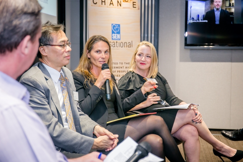 2 men and 2 women in business attire sitting on chairs speaking to each other