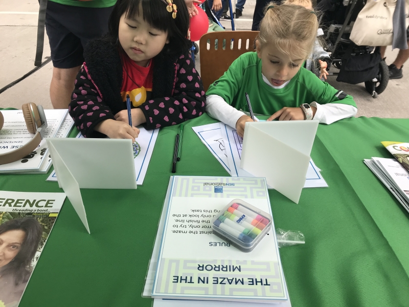 two young girls fill out registration forms