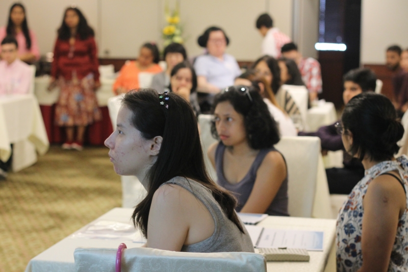 3 women seated listen to the speaking woman