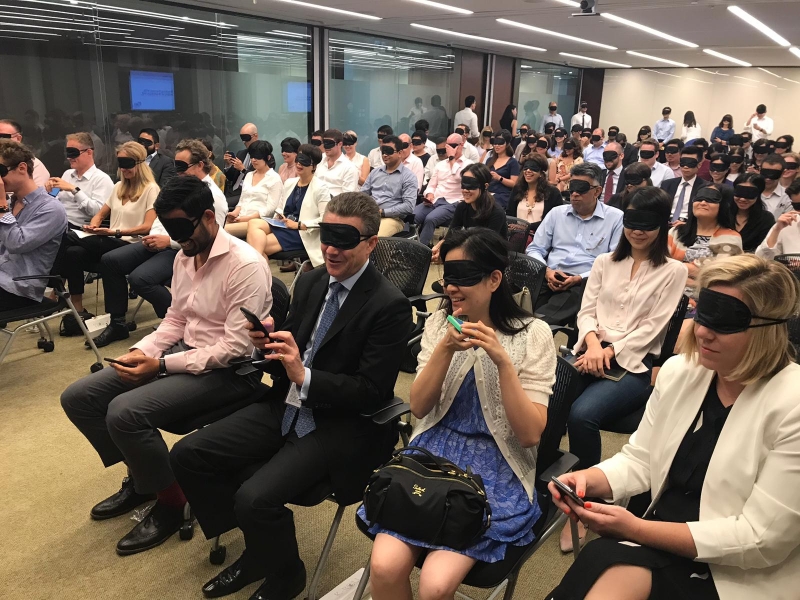 blindfolded seated participants listen